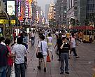 A man using his mobile phone stands in the crowd on Nanjing Road, a shopping street in Shanghai, China.